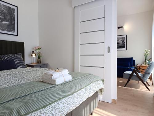 a bedroom with a bed and a chair at Apartament M&M "Wioska Żeglarska" in Sława