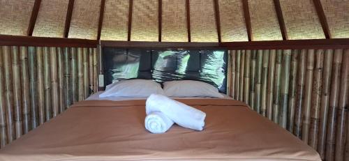 a bed with two towels on top of it at Uma Nirmala Aling-Aling in Singaraja