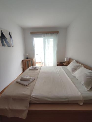 a large white bed with two towels on top of it at Merkur Lux in Budva