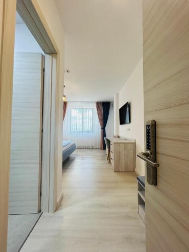 a room with a hallway with a door and a television at Casa Muntenească Alessandro in Piteşti