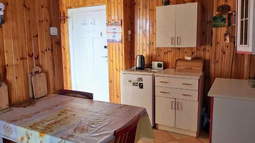 a kitchen with a table and a white refrigerator at Dom Pod Gruszą in Chmielno