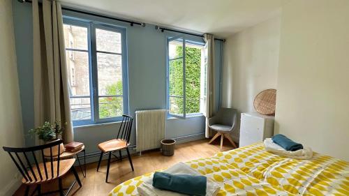 une chambre avec un lit et deux fenêtres dans l'établissement Superbe Maison près du Sacré Cœur, à Paris