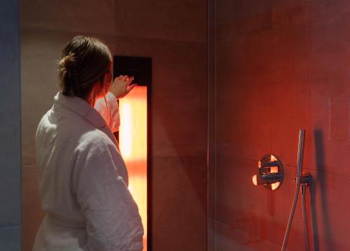 a woman standing in front of a shower at Hotel Gorinchem in Gorinchem