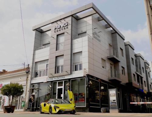 a yellow car parked in front of a building at Ring Inn Apartments in Obrenovac