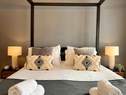 a bedroom with a bed with white sheets and pillows at BEAUTIFUL WINDSOR COTTAGE, AMAZING LOCATION, The Castle, Ascot, Legoland, Free Parking Super Close in Windsor