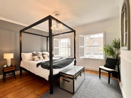 a bedroom with a canopy bed and a chair at BEAUTIFUL WINDSOR COTTAGE, AMAZING LOCATION, The Castle, Ascot, Legoland, Free Parking Super Close in Windsor