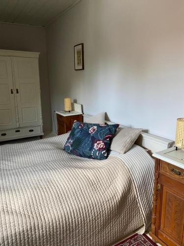a bedroom with a bed with a pillow on it at Kővirág Panzió in Köveskál