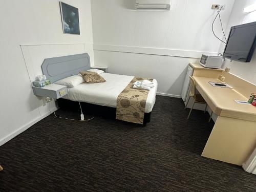a room with a bed and a desk with a computer at Charlton Motel in Charlton