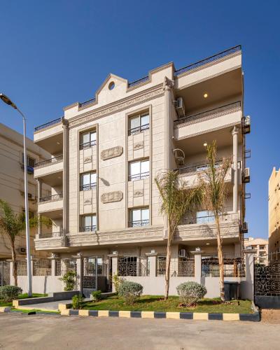 a white building with trees in front of it at Travelholic 90 Residence in Cairo