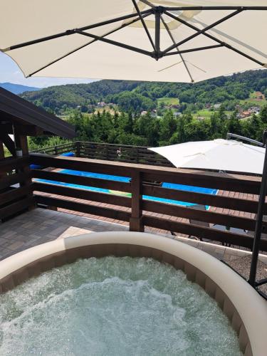a hot tub on a patio with an umbrella at Kuća za odmor MARE in Lepoglava