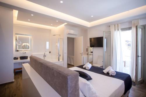 a bedroom with a large bed and a bathroom at VILLA PANAMERA Mykonos, Private Heaven, Supreme View! in Fanari