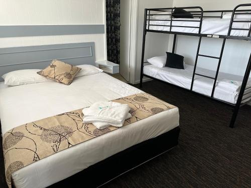 a bedroom with two bunk beds with towels on the bed at Charlton Motel in Charlton