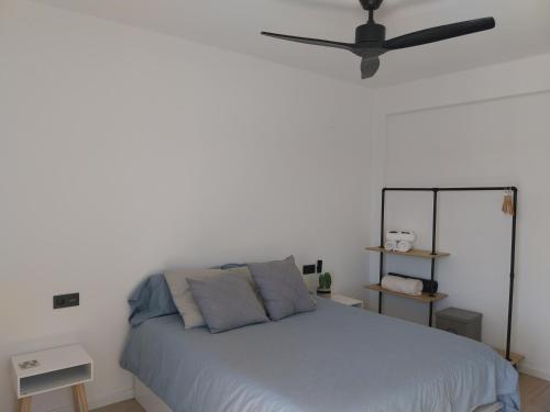 a bedroom with a bed with a ceiling fan at Apartamento grande en Huesca in Huesca