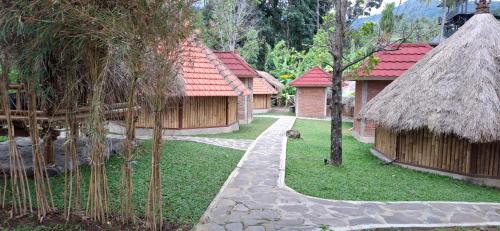 a group of buildings with trees and a path at Uma Nirmala Aling-Aling in Singaraja