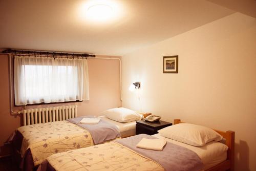 a hotel room with two beds and a phone at Hondo Rooms & Apartments in Sarajevo