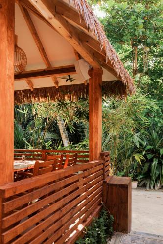 a wooden pergola with a table and benches at Ostrov Palm in Ukulhas