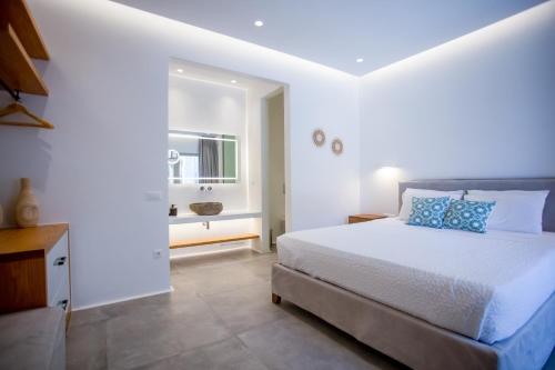 a bedroom with a bed and a bathroom with a sink at VILLA PANAMERA Mykonos, Private Heaven, Supreme View! in Fanari