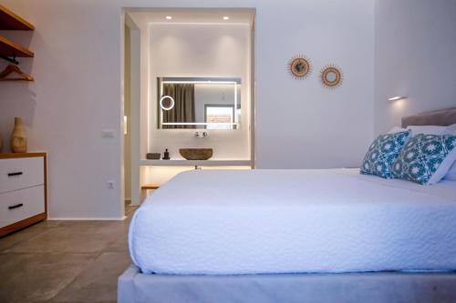 a bedroom with a white bed and a mirror at VILLA PANAMERA Mykonos, Private Heaven, Supreme View! in Fanari
