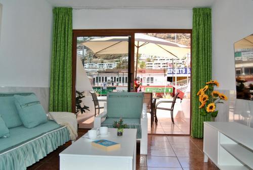 a living room with a couch and a table at Montecarlo 35 or 45 first row with air conditioning & WI-FI & sound insulation in Puerto Rico de Gran Canaria