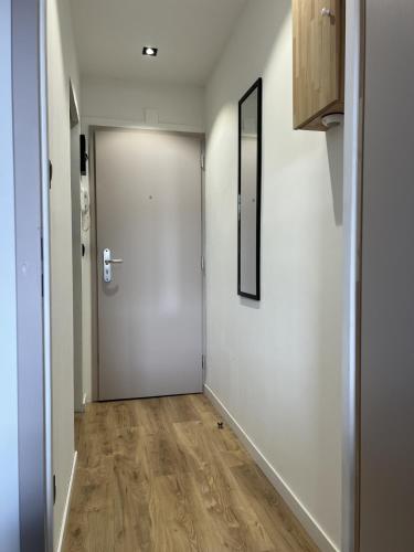 - un couloir avec une porte blanche et du parquet dans l'établissement LE RIO - LOGEMENT ENTIER AU CENTRE DU NEUDORF f1, à Strasbourg