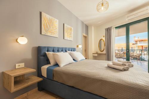 a bedroom with a blue bed with a balcony at Koukos Loft Apartments in Tsilivi
