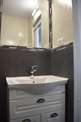 a bathroom with a white sink and a mirror at Ultracentral Mangalia seaside deluxe apartament in Mangalia