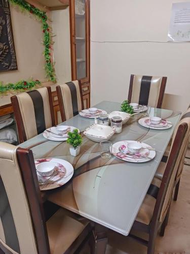 a table with chairs and plates on top of it at Serene Stays at Varanasi - 2BHK Luxury Villa in Varanasi