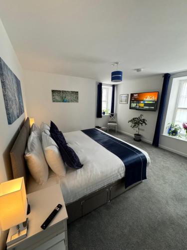a bedroom with a large bed and a couch at The Bear Apartments in Llandovery