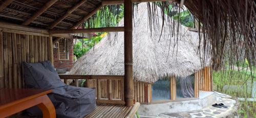 a small hut with a thatched roof at Uma Nirmala Aling-Aling in Singaraja