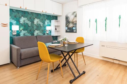 un salon avec une table, des chaises et un canapé dans l'établissement Frontière de Monaco - Studio rénové - AE, à Beausoleil