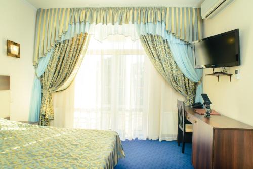Pokój hotelowy z łóżkiem, biurkiem i telewizorem w obiekcie Petrovskyi Brovar w mieście Browary