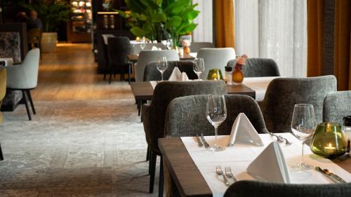 a restaurant with tables and chairs with wine glasses at Hotel Gorinchem in Gorinchem