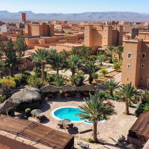 a view of a resort with palm trees and a pool at Kasbah Baha Baha in Nkob