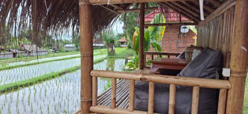 a gazebo with a bed and a piano at Uma Nirmala Aling-Aling in Singaraja