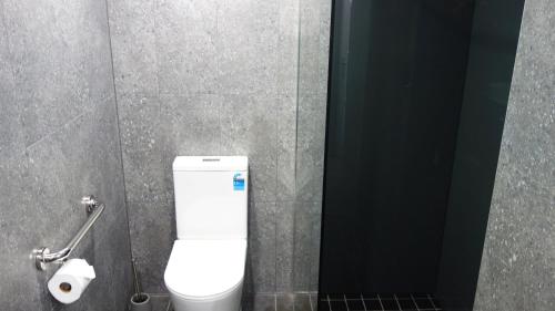 a bathroom stall with a toilet and a roll of toilet paper at Semaphore Splash Apartments in Port Adelaide