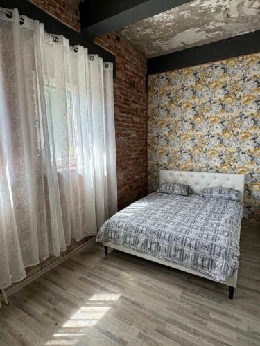 a bedroom with a bed and a brick wall at Villa Bach in Valgeranna
