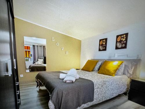 1 dormitorio con 1 cama con paredes de color amarillo y espejo en Laurent Suite, en Santa Cruz de Tenerife