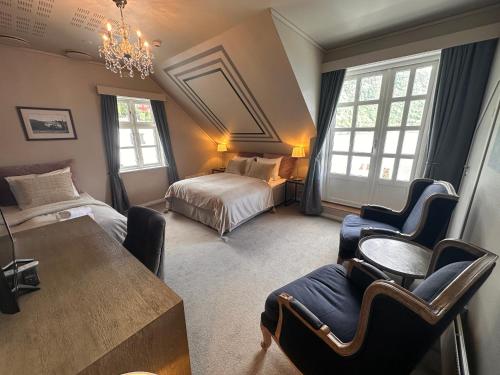 een slaapkamer met een bed en een tafel en stoelen bij Hofslund Fjord Hotel in Sogndal