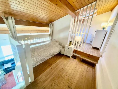 a small bedroom with a bed and a wooden ceiling at Beau loft en duplex proche plage et centre ville in Cabourg