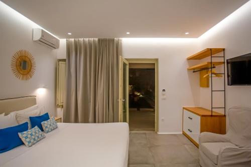 a bedroom with a white bed and a couch at VILLA PANAMERA Mykonos, Private Heaven, Supreme View! in Fanari