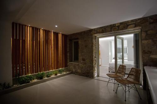 a living room with chairs and a large window at VILLA PANAMERA Mykonos, Private Heaven, Supreme View! in Fanari