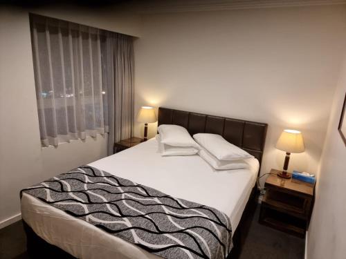 a bedroom with a large bed with two pillows on it at Accommodation Sydney Darling Harbour in Sydney