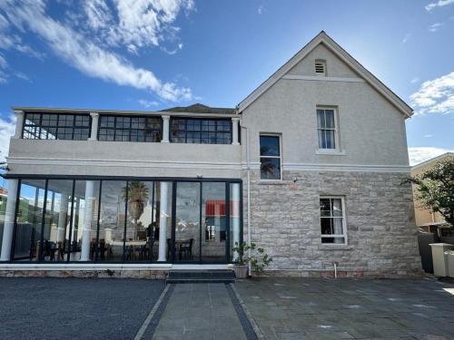 a house with large glass windows on the side of it at THE PLACE Muizenberg in Muizenberg