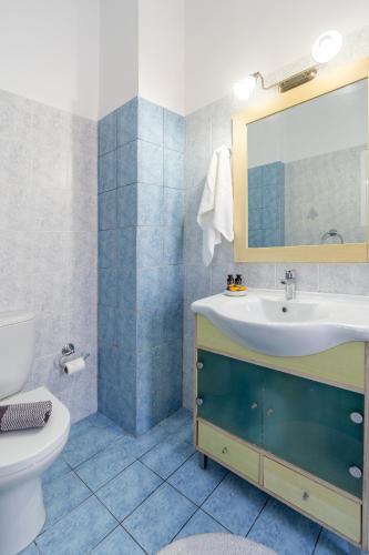 a bathroom with a sink and a toilet and a mirror at West Point House in Agía Thékli