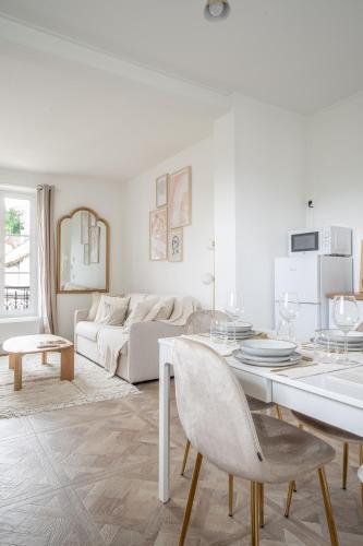un salon blanc avec une table et un canapé dans l'établissement La Versaillaise Bucolique - Stationnement privatif - Proche Gare Chantiers, à Versailles