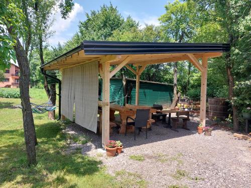 a wooden gazebo with a picnic table in a yard at Katarica in Korenica
