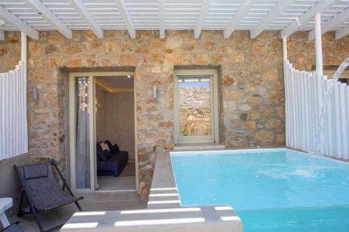 a large swimming pool in a stone building with at VILLA PANAMERA Mykonos, Private Heaven, Supreme View! in Fanari