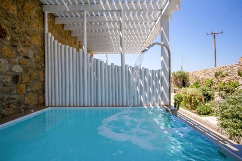 an outdoor swimming pool with a water fountain at VILLA PANAMERA Mykonos, Private Heaven, Supreme View! in Fanari