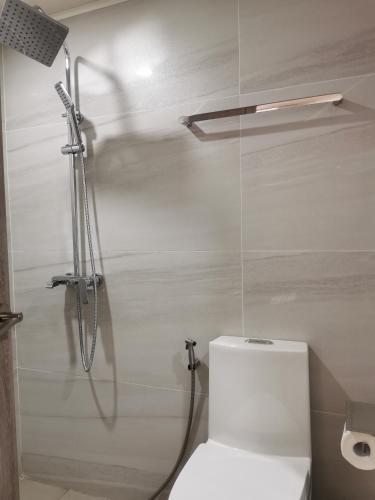 a bathroom with a shower with a toilet and a shower at City Hub 523 in Baguio