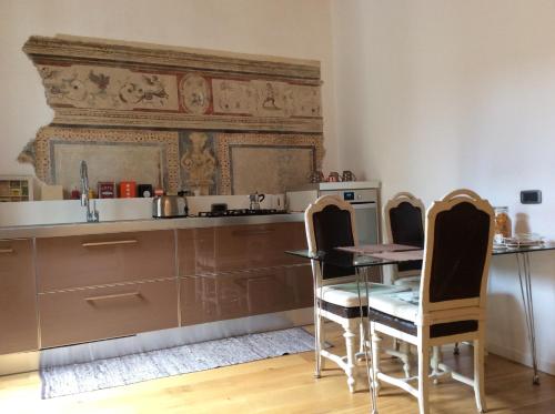 een keuken met een tafel en stoelen en een aanrecht bij Accademia DeLuxe in Bergamo